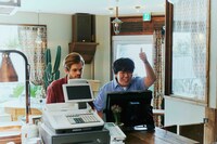 外国人スタッフの横で通訳する紺介（蛙亭・中野）。