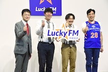 オズワルドと、茨城放送社長の阿部重典氏（左）、オーナーの堀義人氏（右）。