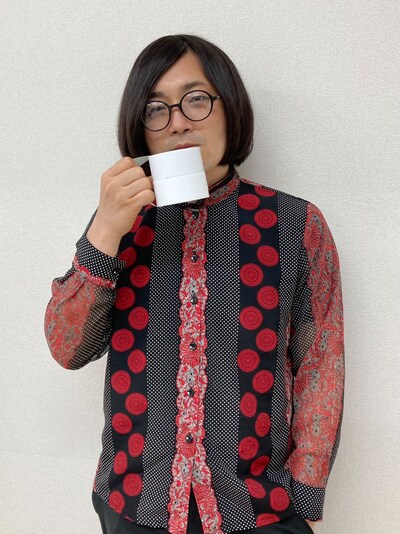 ガムテープをマグカップに見立てて持つ松原タニシ。