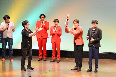 優勝トロフィーを受け取る女将（右）。