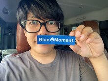 Blue Momentステッカー（小）を持つうしろシティ阿諏訪。
