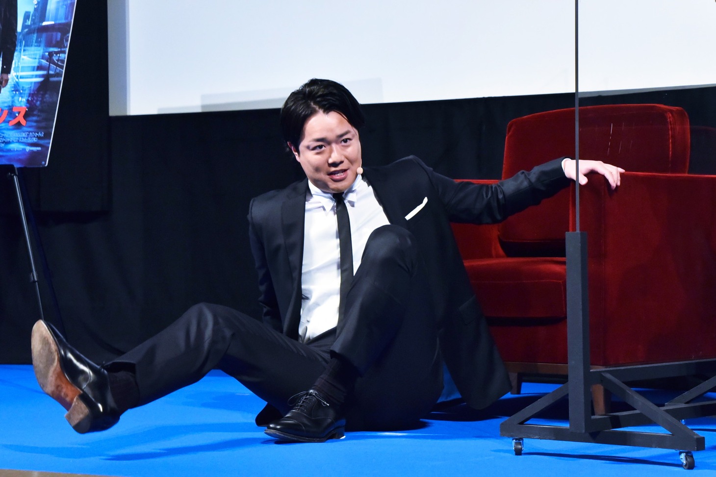 椅子に座る際にコケてみせる、ぺこぱシュウペイ。