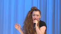 ある女性アーティストになりきってお祝いソングを歌う森田まりこ。