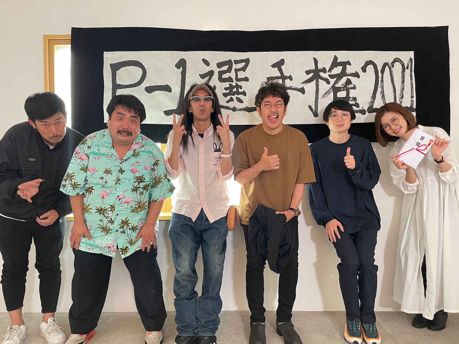 左から岡野陽一、空気階段・鈴木もぐら、沖ヒカル、木村魚拓、空気階段・水川かたまり、青山りょう。題字は鈴木もぐら。
