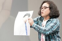 野田クリスタルの写真を弄ぶ松崎克俊。