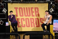 配信開始に間に合わなそうになり慌てて席に戻ったため、不安定な座り方になるロングコートダディ堂前（左）。