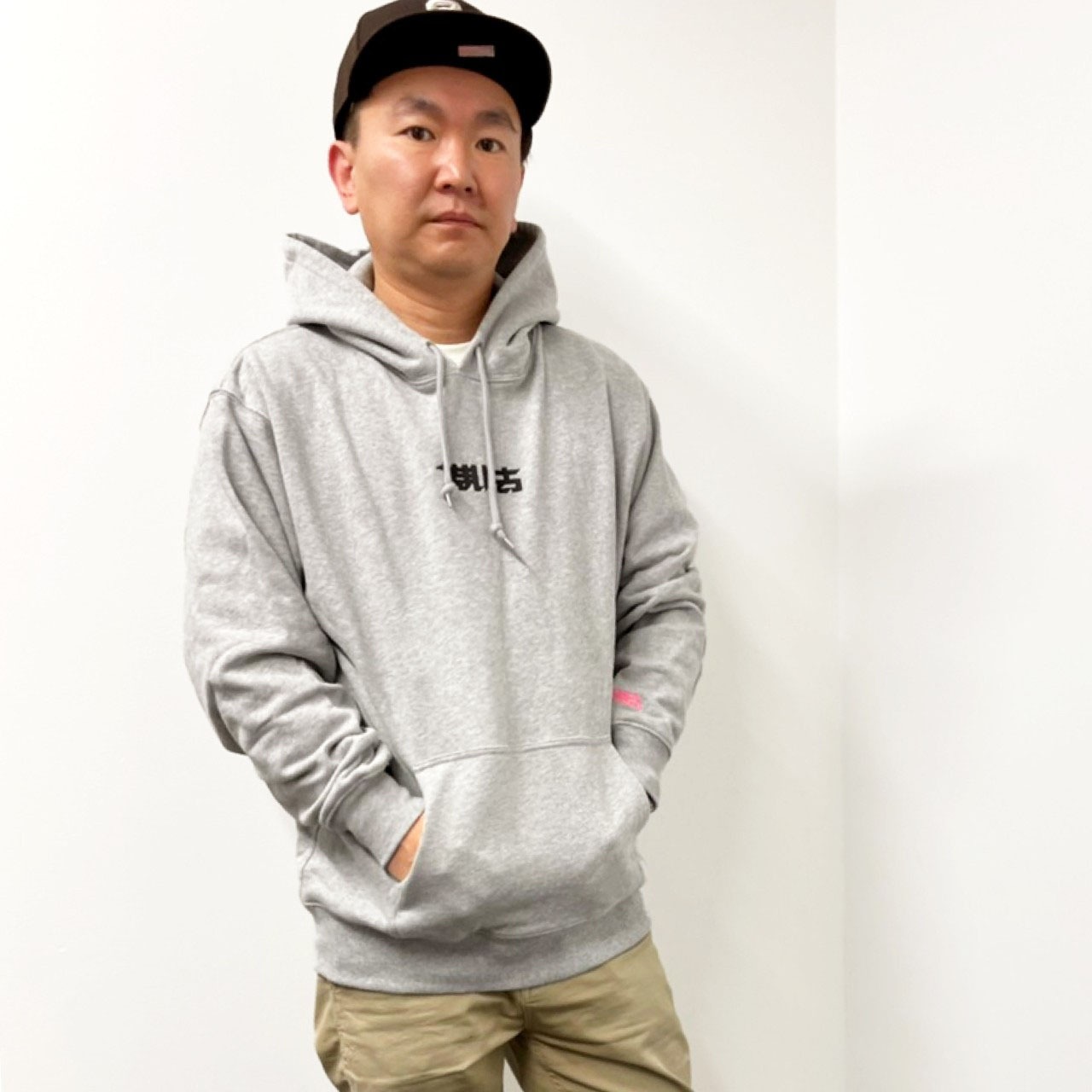 新グッズの「KAMAITACHI LOGO HOOODIE」を着用するかまいたち山内。このグッズはFC会員以外も購入可能。