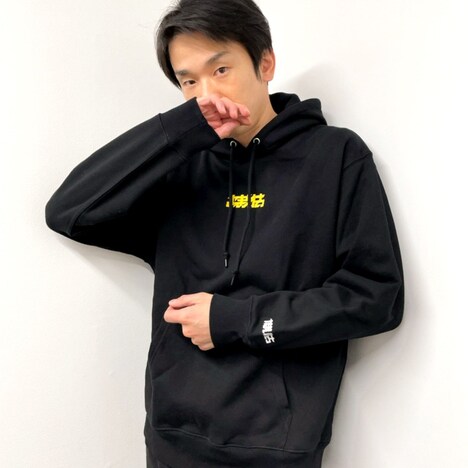 新グッズの「FC限定 OMAETACHI LOGO HOOODIE」を着用するかまいたち濱家。