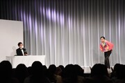 演技中の守谷日和(右)と司会の藤崎マーケット田崎(左)。
