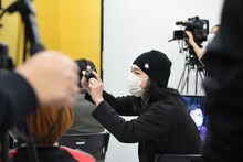 ファインダーを覗くことなくシャッターを切るダイアン・ユースケを撮影する中山功太。