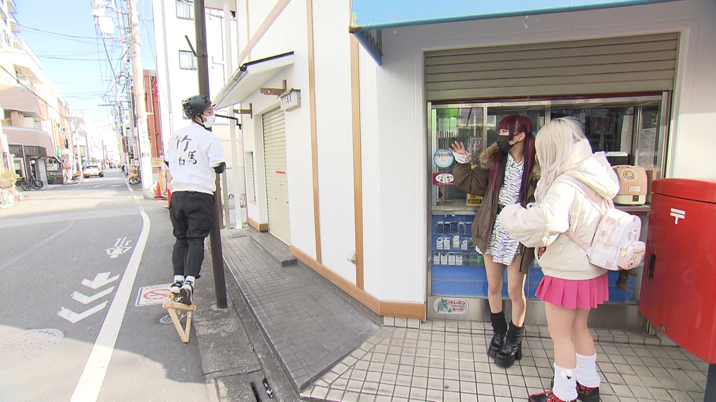 竹馬に乗ったまま街の若者と触れ合うパンサー尾形。