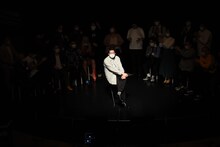 スポットライトの下、エピソードを語る男性ブランコ浦井。