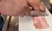 ベーコンをカットする大鶴肥満。