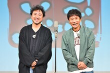 センターマイクを挟んで立つムロツヨシ（左）とダウンタウン浜田（右）。