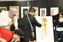 ジミー大西のダイナミックな動きで倒れそうになる作品を抑えようとする一同。