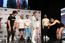 股間を経由して土屋社長に任命状を渡すレイザーラモンHG。