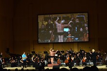 ハリウッドザコシショウが指揮台に立ち、実際のオーケストラを相手に「誇張しすぎた指揮者」のモノマネをしているワンシーン。