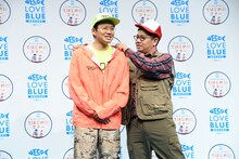 釣りマナー向上大使のミキ亜生（左）の衣装を整えサポートする、釣りマナー向上サポート大使のミキ昴生（右）。