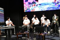 ガーリィレコード高井（右端）の自己紹介中に巻きの合図を出すマヂカルラブリー・野田クリスタル（左端）。