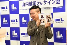 フォトセッション時、お気に入りの写真を見せるも「笑顔なしで」と言われ「なんでや？」と疑問を浮かべるかまいたち山内。