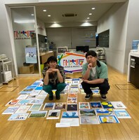 リスナーから届いた暑中見舞いに囲まれるロングコートダディ。