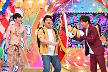 優勝旗を渡されるロングコートダディ兎。