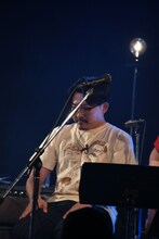 座っているオズワルド伊藤。