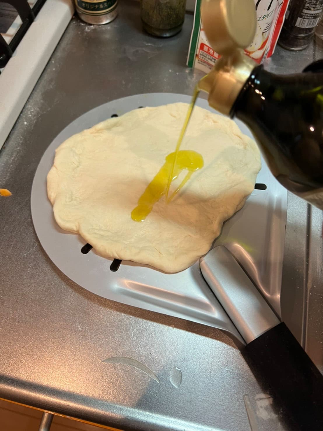 伸ばした生地にオリーブオイルをかける。