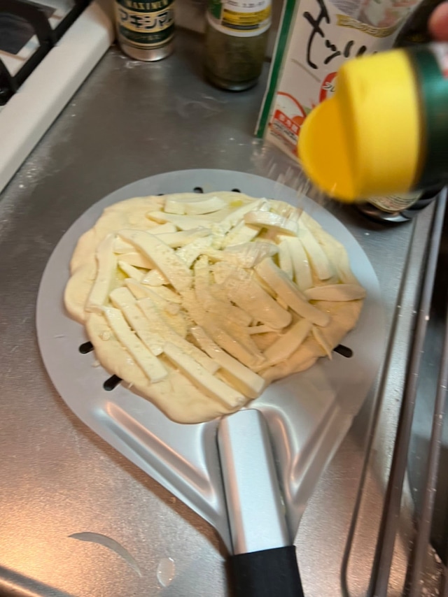 モッツァレラチーズを乗せた生地にパルメザンチーズを振りかける。