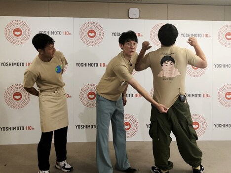 背面にデザインされた兎の絵を見せるロングコートダディ。