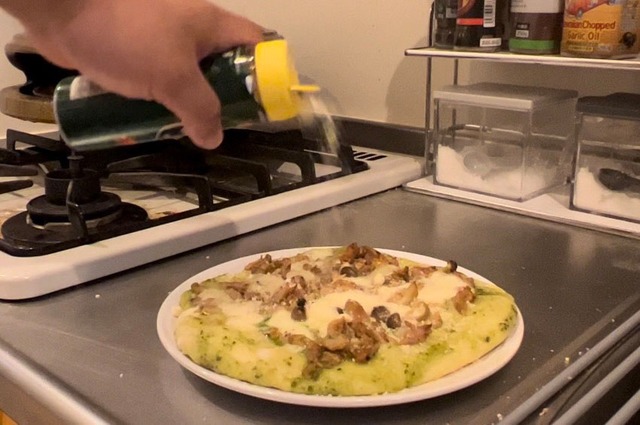 焼き上がったピザに粉チーズをかける。