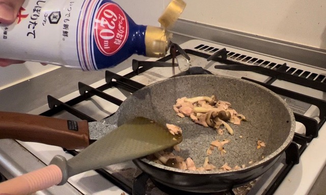炒めているしめじとツナに醤油を少量加える。
