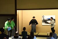 お湯を沸かすまでの時間がかかるはずのお茶がすぐ届き、驚く動作をする野村太一郎（左から3人目）。