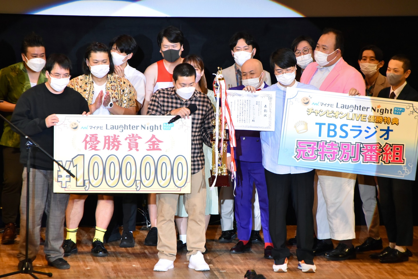 「マイナビLaughter Night」第8回チャンピオンライブで優勝したサスペンダーズ古川（手前中央）、サスペンダーズ依藤（手前右）と、優勝賞金の記載されたボードを同居人の古川と一緒に持つことになったガクヅケ木田（手前左）。