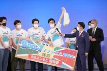 国連広報センターから国連グッズをもらい、「国連に加盟したぞー！」と宣言する男性ブランコ平井。（写真：吉本興業提供）