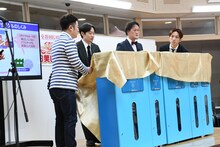 新しい資源回収ボックスの除幕式を行う和牛とアインシュタイン。