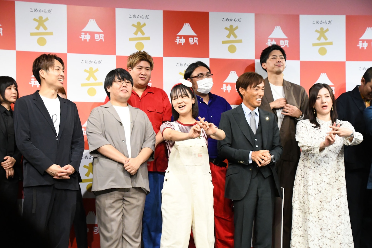 「#こめからだ」を付けて投稿してほしいという広報の案内に、「ハッシュターグ！」とエルフ荒川のギャグで反応する蛙亭イワクラ（前列左から3人目）。