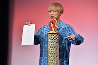 R-1優勝トロフィー返還の誓約書にサインをした、お見送り芸人しんいち。