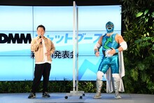 「ゴイゴイスー」のやり方をCMキャラクターのMr.ブースト（右）に説明するダイアン津田。「左手の中指でヘソを感じて」。