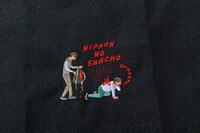 「よしもとコラボ ニッポンの社長のまるでからだの一部 丈夫な肉ナップサック」の刺繍部分。