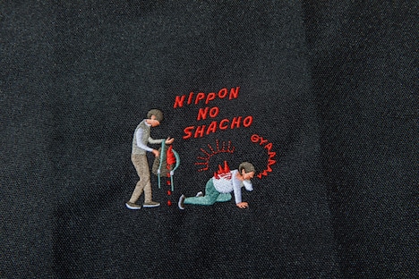「よしもとコラボ ニッポンの社長のまるでからだの一部 丈夫な肉ナップサック」の刺繍部分。