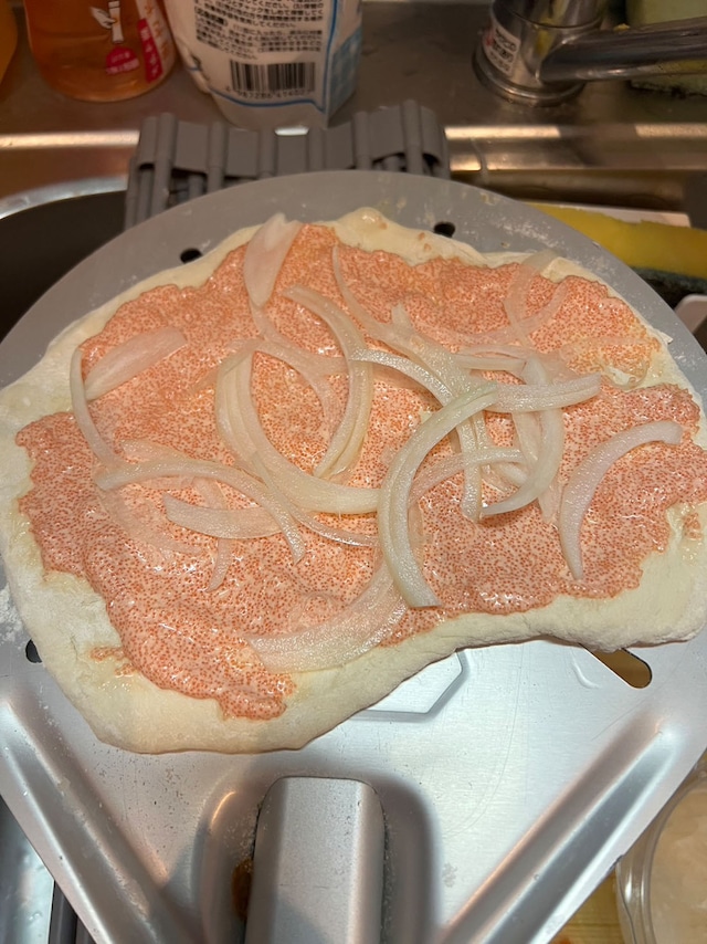 生地にソースを塗り、玉ねぎを乗せる。