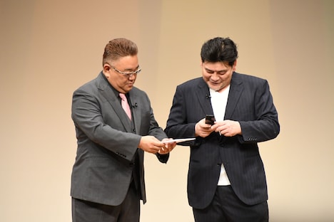 ガラケーでも投票用QRコードを読み取れるのか確かめるサンドウィッチマン富澤。