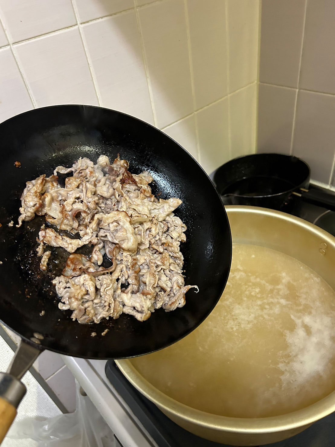 一人暮らしの家のシンクの下から出てきたら笑ってしまうほど大きい鍋に焼き色がついた肉を移す。