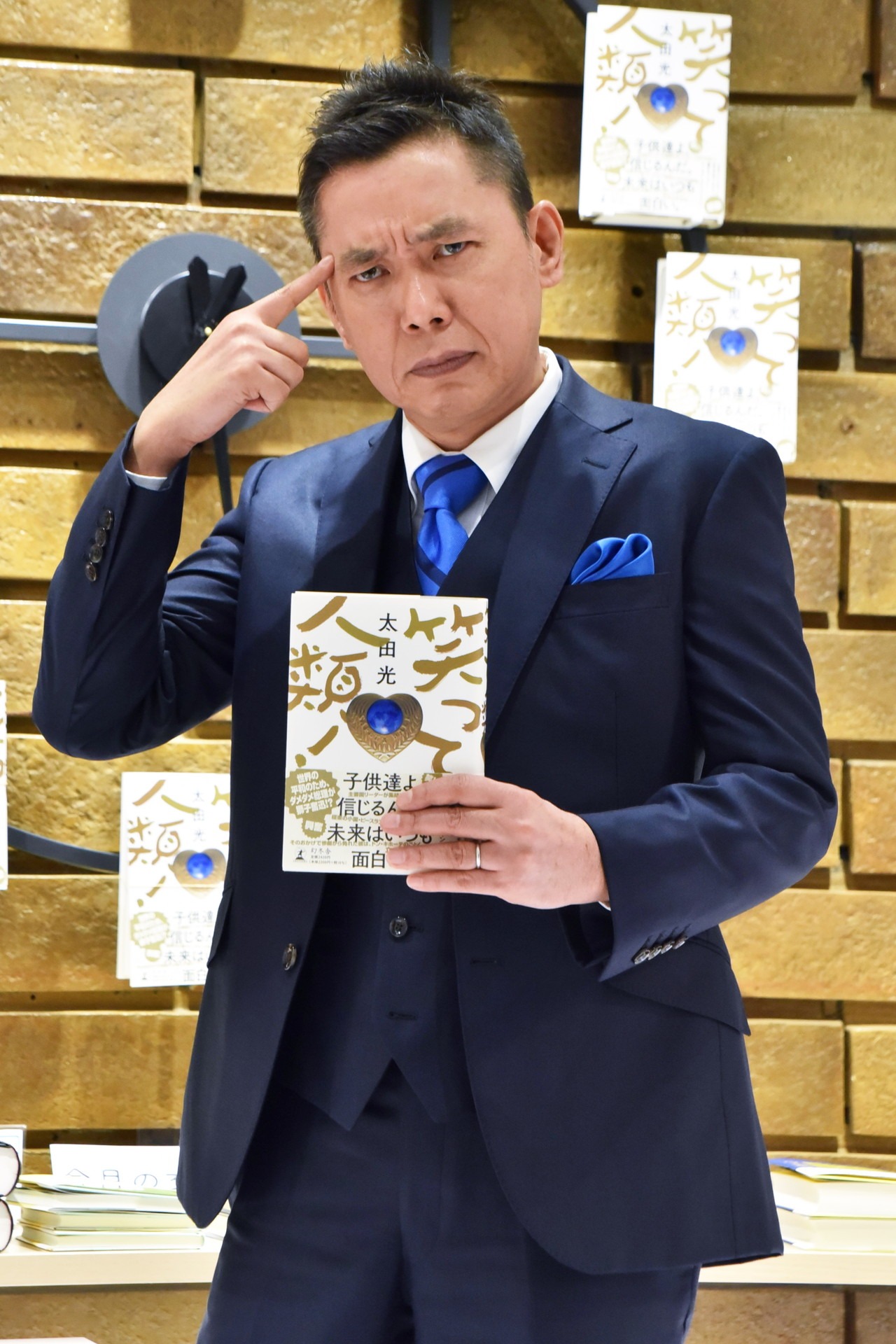 「文豪のように」というカメラマンからのポーズ指定に応じる爆笑問題・太田。
