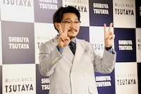 テレビカメラに向かってピースサインを前に出すオズワルド伊藤。