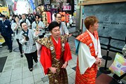 商店街を練り歩く吉田裕とアキ。