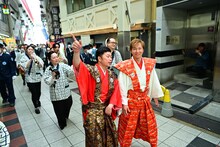 商店街を練り歩くアキと吉田裕。