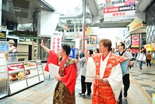 商店街を練り歩くアキと吉田裕。