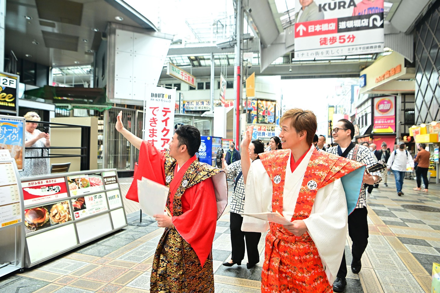 商店街を練り歩くアキと吉田裕。